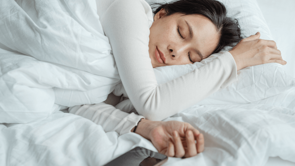 A person sleeping in bed with a white pillow