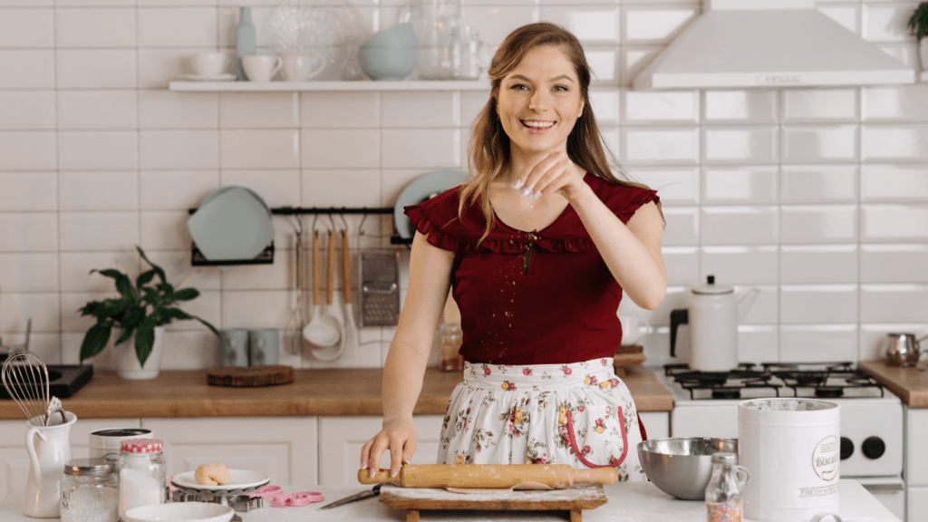 a person in an apron kneading dough in the kitchen