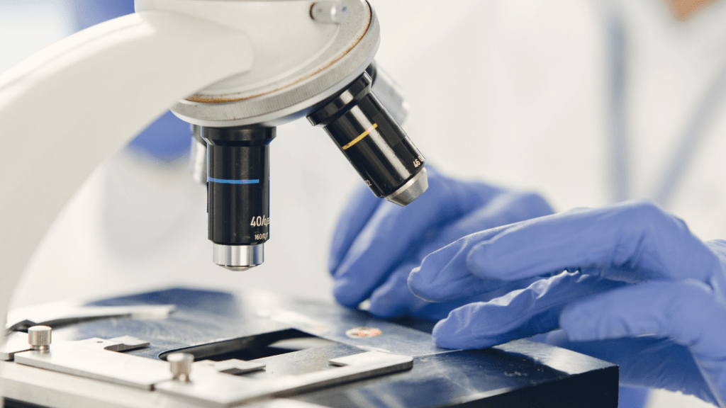 a person in a lab coat is using a microscope