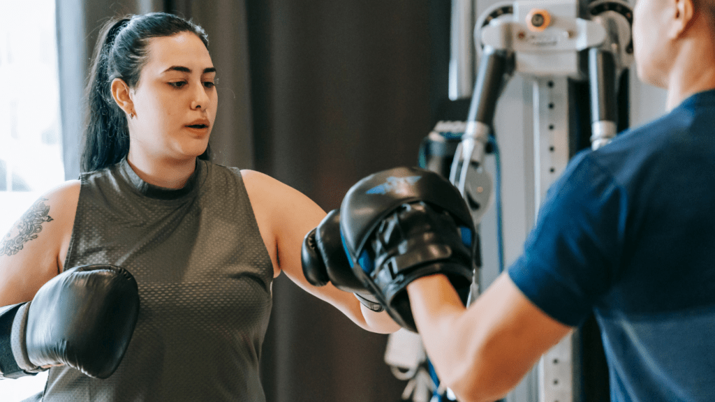 Two people in a gym with boxing gloves