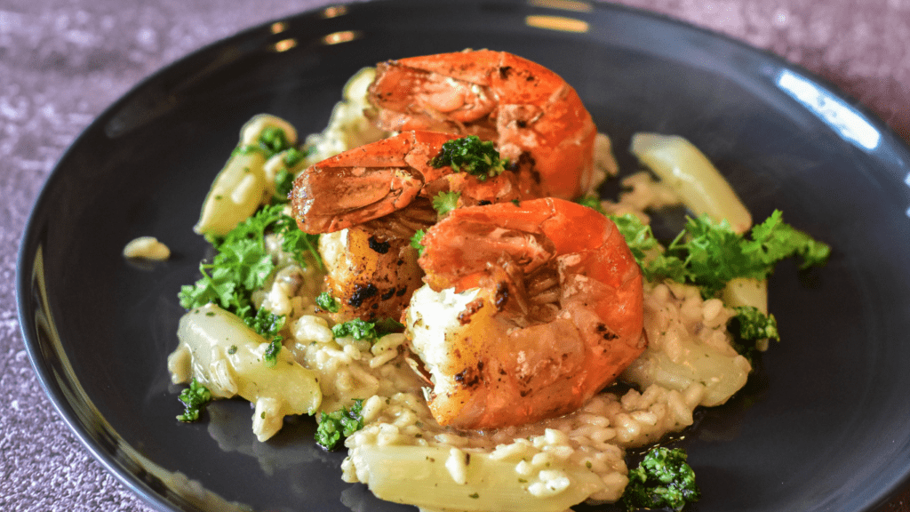 a plate topped with shrimp, rice and broccoli