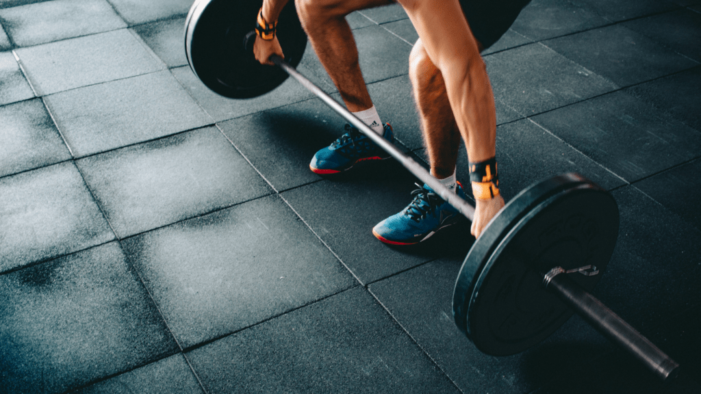 a person is squatting with a barbell in a gym