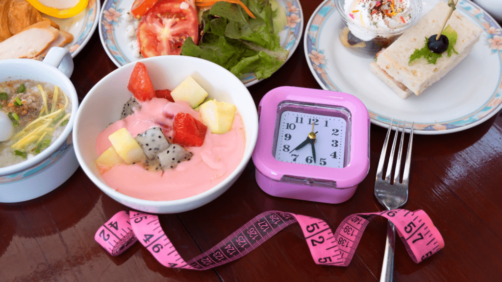 an alarm clock sits on a table next to a plate of food