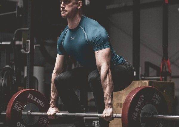 Man in Blue Shirt Lifting a Barbell